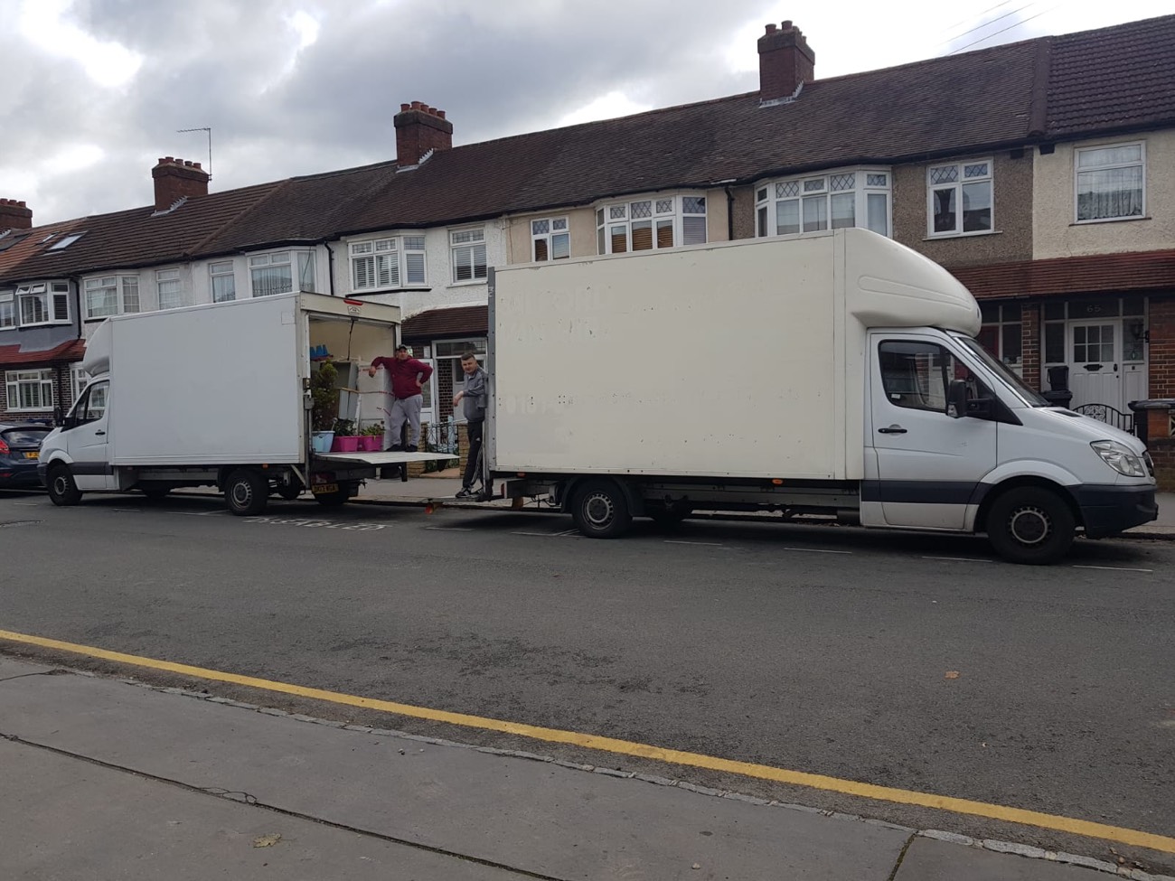Two Local Express Removals Luton vans and two movers loading furniture outside a terraced London house