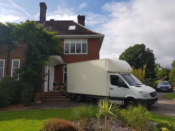 A Local Express Removals Luton van backed up to the door of a large detached house on moving day